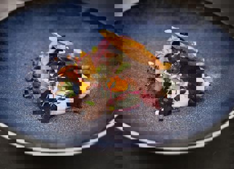 A plate of salad, egg and bread on a blue bowl.