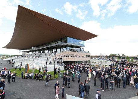 Crowds gathered outside a building at a racecourse.