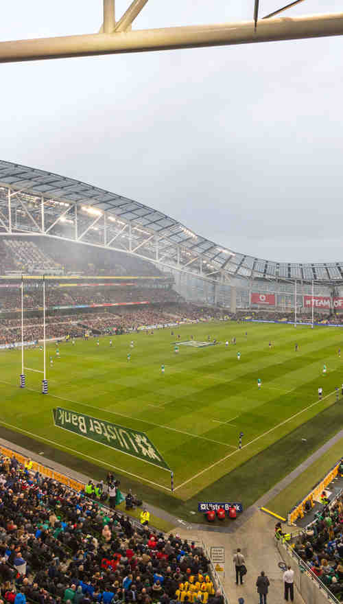 A view of the pitch at the Aviva Stadium with a rugby match taking place with a full crowd.